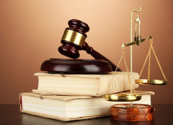 17037939 - golden scales of justice, gavel and books on brown background